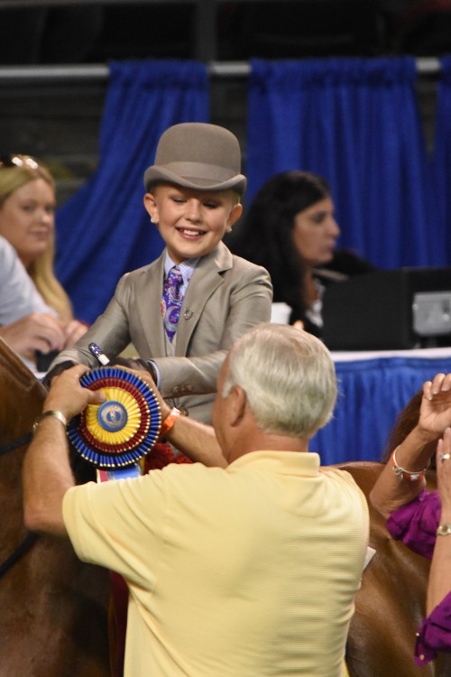 Bill Waller pins the ribbon on WalkTrot Equitation 9 10 Years Old Worlds Champion of Champions Molly Crim